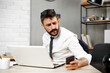 © JustLife - Handsome businessman using the phone in the office.  Young manager typing a message