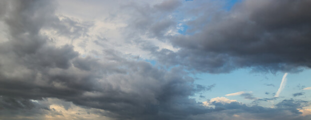 Wall Mural - dramatic dark sky with rays and white clouds at sunset