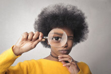 Young Woman Looks Through A Magnifying Glass