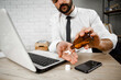 © JustLife - Portrait of handsome businessman drinking medicine in the office. Tired businessman taking medication..