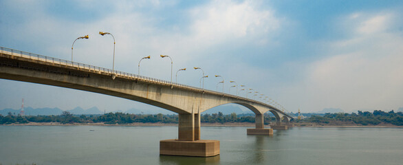  Third Thai–Lao Friendship Bridge, is a bridge over Mekong river that connects Nakhon Phanom Province in Thailand with Thakhek, Khammouane in Laos in cloudy blue sky day