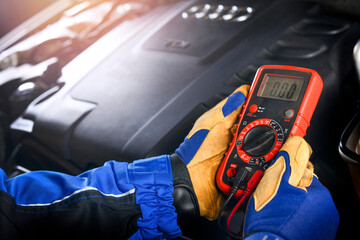 Poster - Car mechanic in service center using multimeter detail.