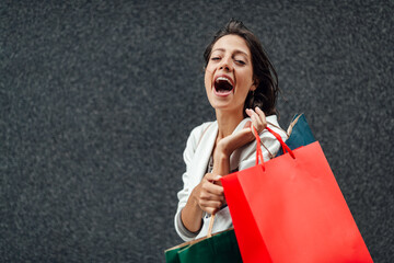 Poster - Portrait of young happy smiling woman with shopping bags