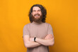 © Vulp - Portrait of joyful smiling bearded hipster man with crossed arms over yellow background looking at the camera