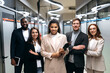 © Kateryna - Successful influential entrepreneurs in stylish suits are standing in office with cross hands. Happy multiracial business partners looking confidently at the camera, smiling