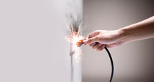 Hand Connecting Electrical Plug Cause Electric Shock, Idea For Causes Of Home Fire, Electric Short Circuit, Electrical Hazard Can Ignite Household Items