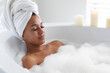 © Wavebreak Media - African american woman relaxing in bathtub at bathroom