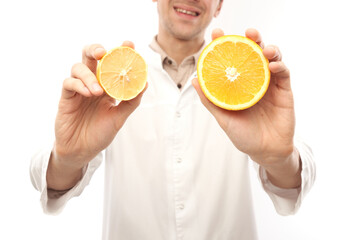 Portrait of a positive smiling male doctor nutritionist with oranges. Eat vitamin C, stay healthy, diet food in cold and flu season concept