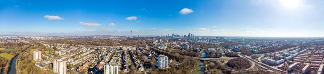 Beautiful aerial Panorama 180 view on european finance center city Frankfurt am Main downtown skyline in spring.  Blue sky, clouds, green trees. Hesse, Germany