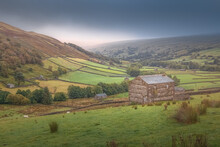 Old Stone Barns Near Thwaite In The Moody Rural Rolling Hills And English Countryside Pastoral Landscape Of The Yorkshire Dales National Park, England, UK.