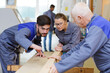 © auremar - trainee carpenters discussing woodworking project