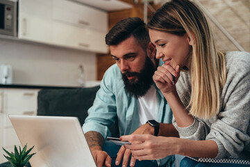 Wall Mural - Couple shopping online with laptop