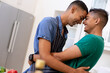 © WavebreakMediaMicro - Diverse gay male couple spending time in kitchen embracing and smiling