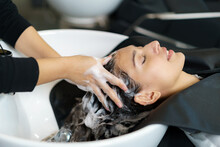 Hairdresser Is Applying Shampoo And Massaging Hair Of A Customer. Woman Having Her Hair Washed In A Hairdressing Salon..