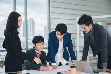 Wall Mural - Group of young business people sit at their desks with smiling colleagues together in the office.  Meeting business people  planning concept, laptop meeting ideas. Concentrate on work. LGBT teamwork.