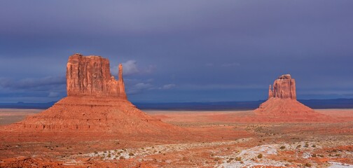 east and west mitten buttes in winter against a stormy sky in the navajo tribal park of monument valley, utah