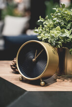 Close-up Of Clock With Potted Plant On Table