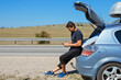 © aaalll3110 - the guy looks for the road in the navigator on the phone. the tourist stopped on the road. man and open car trunk. travel by car