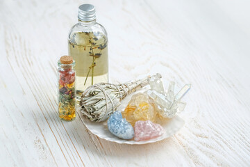 Wall Mural - Healing gemstones, white sage bundle, magic bottles on wooden table. holy sage, incense for fumigation, cleaning, good energy. Wiccan Witchcraft. Crystal Ritual, esoteric spiritual practice concept 