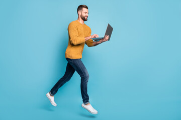 Canvas Print - Full length body size view of nice cheerful skilled focused guy jumping going using laptop isolated over bright blue color background