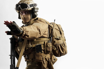 Male soldier in tactical equipment and uniform (coyote brown color) . Shot in studio on a white background