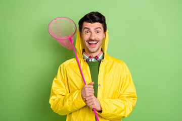 Poster - Photo of brunet impressed guy hold net wear cloak isolated on green color background