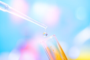 chemical test tube with yellow liquid and a pipette with a drop of liquid. chemical laboratory with 