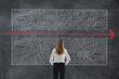 © New Africa - Businesswoman looking at chalkboard with illustration of maze