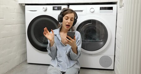 Wall Mural - Woman enjoys while washing clothes at home