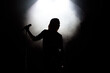 © nagaets - black silhouette of female singer with white spotlights in the background