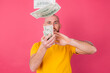 © Анастасия Каргаполов - European man on pink red background with fan on 100 dollars happy excited throwing in air isolated space