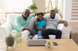 © WavebreakMediaMicro - Portrait of senior african american fon couch smiling with adult son and grandson embracing