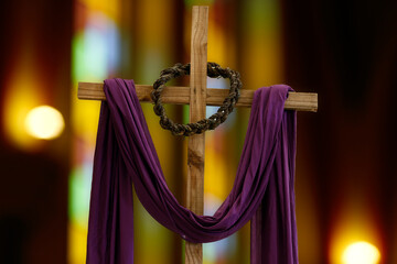 wooden cross, crown of thorns and purple fabric