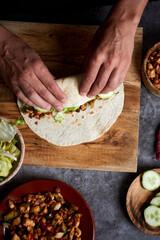 Canvas Print - young man rolls a durum or a burrito