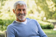© PhotoAlto - Portrait of smiling mature man sitting on chair
