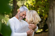 © PhotoAlto - Smiling mature couple embracing each other in backyard