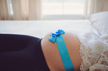 Blue Ribbon On Belly Of Pregnant Woman