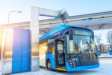 High-voltage electric charging station for charging electric buses at the final stop of the city route. Bus at the final stop with an open door.