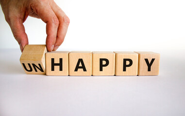 Be happy, do not unhappy symbol. Businessman turns the wooden cube and changes the word 'unhappy' to 'happy'. Beautiful white background. Business, happy or unhappy concept. Copy space.