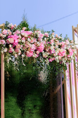 Wall Mural - Close up view of fashion arch decorated with fresh roses and greenery. Concept of wedding ceremony details.