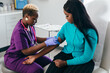 © Gerald R Carter Jr/Creative Flame - Black nurse collects blood sample from female patient at doctors office