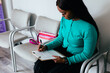 © Gerald R Carter Jr/Creative Flame - Black woman completing medical paperwork at doctor office in waiting room