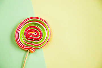 Canvas Print - Cute twisted lollypop on the green-and-yellow background