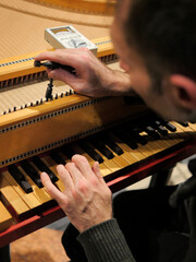 Musician tuning a harpsichord before a concert.