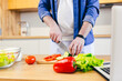 © Liubomir - Close-up photo, a man at home chops vegetables in the kitchen, prepares breakfast