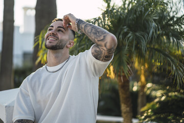 Wall Mural - Shallow focus shot of a handsome Caucasian Spanish man with tattoos posing outdoors