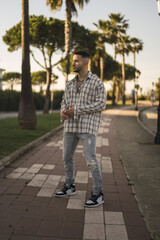 Sticker - Vertical shot of a handsome Caucasian Spanish man with tattoos posing outdoors