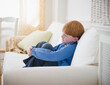 © jamie grill photography/Tetra Images - Boy (8-9) sitting on sofa