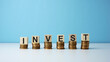 © Shafawi - Business and banking concept. Block letters with word 'INVEST' on top of stacking coins.