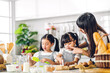 © Art_Photo - Portrait of enjoy happy love asian family mother and little toddler asian girl daughter child having fun cooking together with baking cookie and cake ingredient on table in kitchen